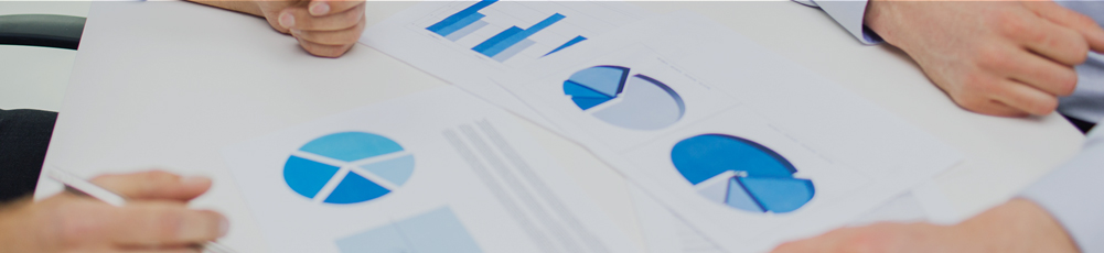 두 사람이 책상위에 펼쳐진 그래프 서류를 분석하는 이미지입니다.